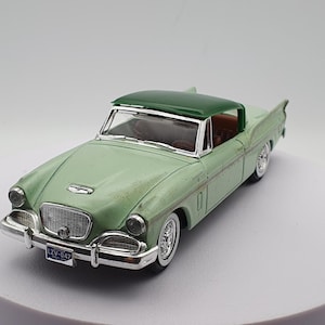 Könnte beinhalten: Ein grünes Modellauto aus den 1950er Jahren mit einem weißen Nummernschild mit der Aufschrift "LZV-047".