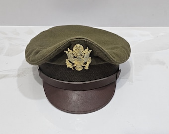 May include: A green military style hat with a brown leather band and a gold eagle insignia.