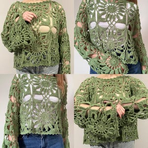 May include: A green crochet top with long sleeves and a floral design. The top has a round neckline and open sections throughout the design. The crochet work is detailed and intricate, creating a unique and textured look. The top is a bohemian style.