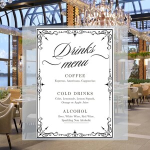 May include: A restaurant drinks menu with a decorative black border. The menu lists coffee, cold drinks, and alcohol options. The background shows a modern restaurant interior with chandeliers and seating.