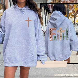 May include: A heather grey hooded sweatshirt with a cross graphic on the front and the word "FAITH" with bible verses on the back.