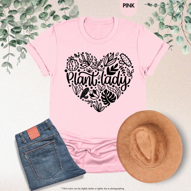 May include: A pink t-shirt with a black heart design featuring the text "Plant lady" surrounded by plant illustrations.
