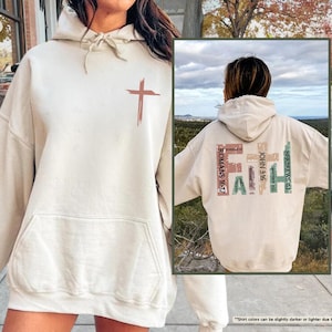 May include: A beige hoodie with a cross graphic on the front and the word "FAITH" spelled out with bible verses on the back. The hoodie has a drawstring hood and a kangaroo pocket.