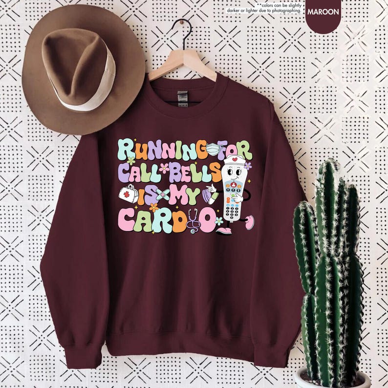 May include: Maroon sweatshirt with a graphic of a nurse's call button with the text "Running for call*bells is my cardio*"