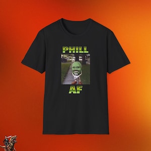 May include: Black t-shirt with a green M&M character wearing a white shirt and tie. The text "PHILL AF" is printed on the shirt.