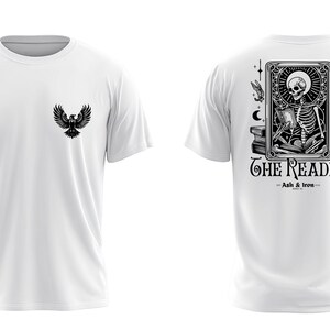 以下が含まれることがあります： 胸元に小さな黒い鳥のグラフィックが描かれた白いTシャツ。背面には、タロットカードのように縁取られた本を読む骸骨の大きなモノクロイラストと、THE READERおよびAsh & Ironというテキストがプリントされています。