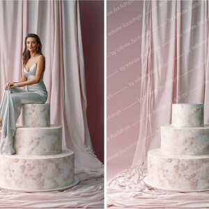 May include: A three-tiered cake with a marble-like design, featuring a light pink and beige color scheme. The cake is set against a backdrop of pink fabric and a woman in a silver dress is sitting on top of the cake.