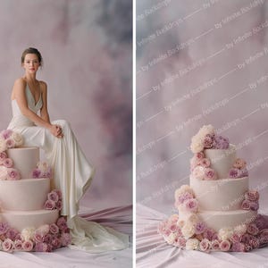 May include: A three-tiered cake decorated with pink and cream roses. A person in a white dress is seated on the cake. The background is a soft, blurred mix of pink and gray.