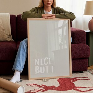 Minimalist typography print in neutral tones, featuring a humorous phrase in soft grey lettering on a white background. The poster is presented in a casual, modern setting, highlighting its versatility for various spaces like bathrooms, bedrooms, or offices with a contemporary and lighthearted design approach.