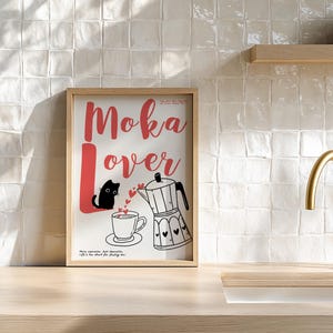 May include: A framed print with the words "Moka Lover" in red script. The image features a black cat, a coffee cup, and a moka pot with heart details. The background is a kitchen setting.