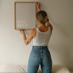 Modern wall art poster with a simple white background and light grey text reading “Nice Butt.” The design is minimalist, focusing on typography and negative space. Displayed in a lifestyle mockup, it complements Scandinavian and clean aesthetic interiors, making it ideal for stylish and understated home decor.