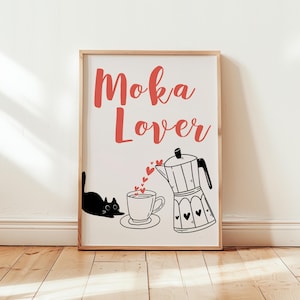 Puede incluir: Una impresión enmarcada en blanco con el texto "Moka Lover" en letras rojas. Un gato negro se sienta junto a una taza de café con corazones flotando desde una cafetera.