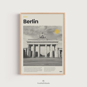 Może przedstawiać: Oprawiony wydruk przedstawiający Bramę Brandenburską w Berlinie, Niemcy, w czerni i bieli. Słowo "Berlin" znajduje się na górze, z żółtym okręgiem reprezentującym słońce. Wydruk zawiera tekst na dole i inicjały "BER".