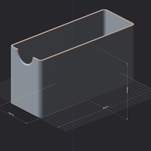 Puede incluir: Un contenedor de almacenamiento rectangular gris con esquinas redondeadas y un recorte semicircular en el borde frontal. La representación digital muestra dimensiones de 85,25 mm de ancho, 244,0 mm de largo y 107,0 mm de alto sobre una cuadrícula.