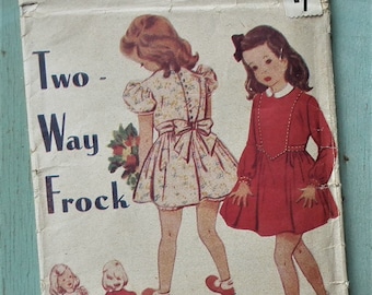 Op de afbeelding: Vintage naaipatroon getiteld "Two-Way Frock" met illustraties van meisjes in jurken. Het patroon is van Weldons, gemarkeerd met "So-Easy" en patroonnummer 131, voor de leeftijd van 7 tot 8 jaar. De omslag is verouderd, tegen een lichtblauwe achtergrond.