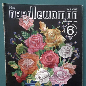 May include: The Needlewoman magazine cover from September 1934 features a colorful cross-stitch design of a bouquet of roses in a blue vase. The text "FREE Transfer of Flower Borders" is printed at the bottom.