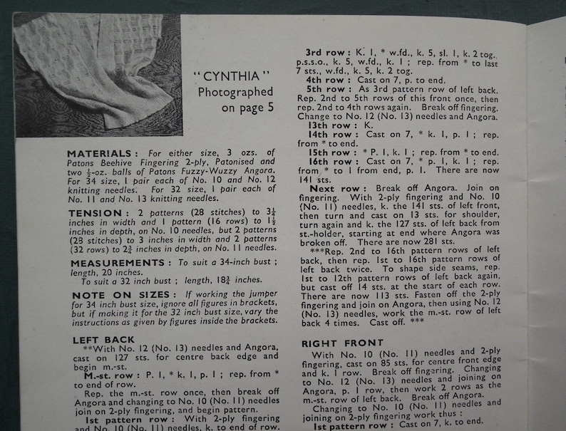 Op de afbeelding: Een close-up van een breipatroon voor een "Cynthia" trui. Het patroon bevat instructies voor de rug, voorkant en steken. Het patroon gebruikt Patons Beehive Fingering 2-ply en Patons Fuzzy-Wuzzy Angora garen. Het patroon is voor maten 32 en 34 inch.