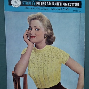 May include: A vintage knitting pattern booklet featuring a woman wearing a yellow knitted blouse with a daisy patterned yoke. The booklet cover has the title "Strutt's Milford Knitting Cotton" and the text "Blouse with Daisy Patterned Yoke".