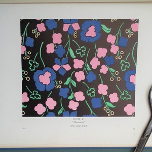 May include: A page from a book featuring a floral pattern design. The design includes blue and pink flowers with green leaves and stems on a black background. The text reads "PLATE VI" and "Moonlight" (Four-colour design).