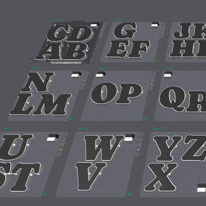以下が含まれることがあります： 9つのグリッドパターンプレート上に配置された3Dアルファベット文字のデジタル表示。文字は白の輪郭を持つダークグレーで、AからZまでのアルファベット順に並べられ、ピリオドも含まれており、複数のセクションに整理されています。
