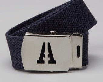 May include: A dark blue canvas belt with a silver buckle featuring a stylized "A" logo.