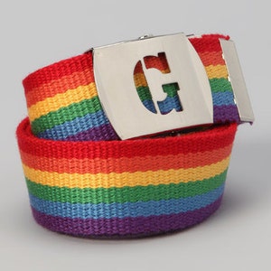 以下が含まれることがあります： 虹色のストライプのベルトに、Gの文字が刻まれた銀色のバックルが付いている。