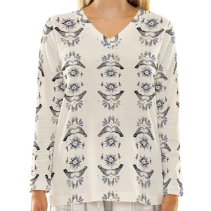 May include: White long-sleeved shirt with a V-neck and a repeating pattern of blue and gold birds with a stylized eye design.