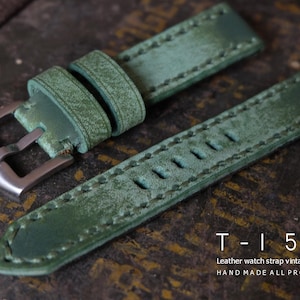 May include: Green leather watch strap with a vintage style, featuring a silver buckle and visible stitching. The strap has a distressed finish and the text "T-150 Leather watch strap vintage style HAND MADE ALL PROCESS".