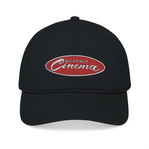 May include: Black baseball cap with a curved brim. The cap features an embroidered logo in a red oval with the words "Beverly Cinema" in white script.