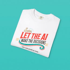 May include: A white t-shirt featuring a graphic design with the text "Sure, LET THE AI MAKE THE DECISIONS" in red and black, accented by a teal curved line and the smaller text "what could possibly go wrong" in a simple black font.