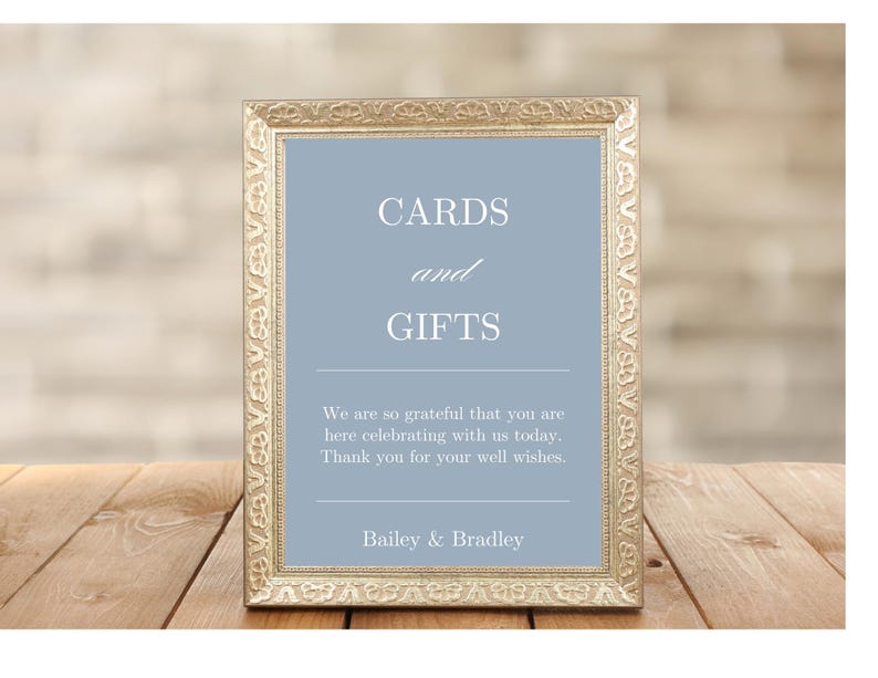 K&ouml;nnte beinhalten: Ein goldfarbener Rahmen mit einem hellblauen Hintergrund und dem Text "CARDS and GIFTS". Das Schild enth&auml;lt auch den Text "We are so grateful that you are here celebrating with us today. Thank you for your well wishes. Bailey & Bradley."