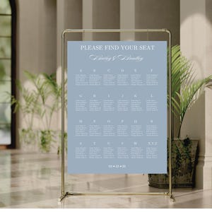K&ouml;nnte beinhalten: Ein hellblauer Hochzeitssitzplan mit dem Text "PLEASE FIND YOUR SEAT" und "Baring & Straitlig" in einer kursiven Schrift. Der Plan ist in alphabetische Abschnitte unterteilt, wobei die Namen der G&auml;ste unter jedem Buchstaben aufgef&uuml;hrt sind.