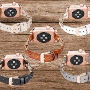 May include: Four different Apple Watch bands in black, brown, white, and gray leather. Each band has a braided design and a rose gold buckle.