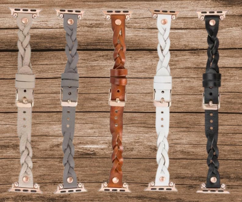 May include: Five braided leather watch bands in different colors: gray, brown, white, black, and beige. The bands are all the same style, with a braided design and a rose gold buckle.