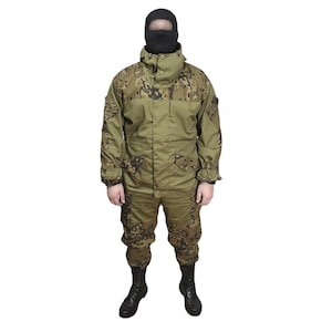 May include: A camouflage military uniform in shades of green and brown, with a jacket and matching trousers. The outfit includes a black balaclava and black boots. The uniform is designed for concealment in various environments.