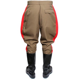 May include: A pair of brown riding breeches with red stripes down the sides. The breeches are worn with black leather boots.