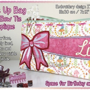May include: Pink quilted make-up bag with a pink bow applique and the name "Lina" embroidered on it. The bag is 7x12 inches and is designed for an embroidery hoop.  The bag is fully lined and has no visible seams.
