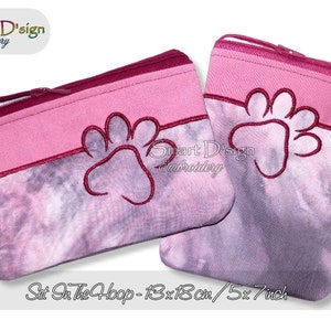 May include: Two pink zippered pouches with a paw print design embroidered on each. The pouches are 5x7 inches and are set in the hoop.