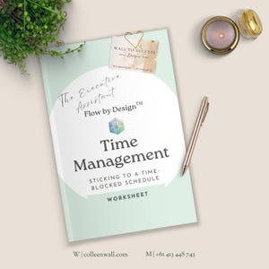May include: A workbook titled "Time Management" with the text "The Executive Assistant" and "Flow by Design." A gold pen, a small candle, and a business card are next to the workbook. The workbook is light green and white.