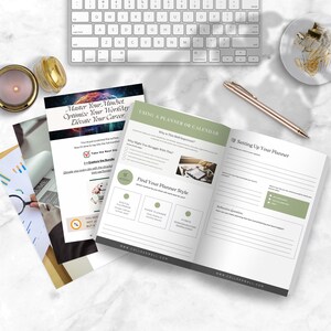 May include: An open planner with green accents, a pen, and a keyboard on a white marble surface. The planner's pages include the text "Using a Planner or Calendar" and "Find Your Planner Style". A candle and gold paper clips are also visible.