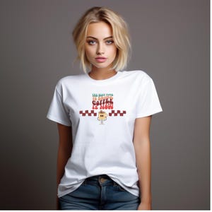 Puede incluir: Camiseta blanca con un gráfico de estilo retro que dice "El mejor momento para tomar café es ahora" con una ilustración de taza de café de dibujos animados.