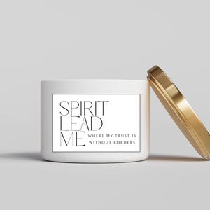 May include: White candle jar with a gold lid. The jar has a black and white label with the text "SPIRIT LEAD ME WHERE MY TRUST IS WITHOUT BORDERS".