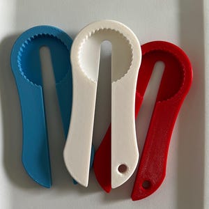 May include: Three bottle openers in blue, white, and red. The openers are made of plastic and have a textured surface.