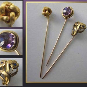 May include: A collection of antique gold-toned hat pins. The pins feature various designs, including a knot, a square amethyst stone, and a floral motif with blue accents. The pins are displayed against a light background.