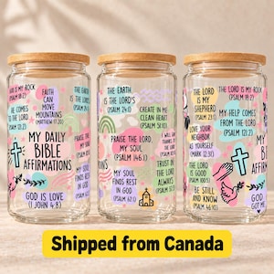 May include: Three clear glass tumblers with bamboo lids, each featuring colourful pastel shapes and black text displaying Bible affirmations and scripture references. Designs include crosses, a dove, a church, and rainbows on the glass surface.