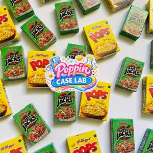 May include: A collection of miniature Kellogg's Apple Jacks and Corn Pops cereal boxes scattered across a white surface, featuring a central sticker with the text Poppin Case Lab, a rainbow, a flower, and a beaker icon, all in vibrant colors.