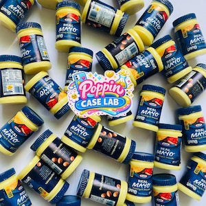 May include: A collection of Kraft Real Mayo jars with blue lids and labels featuring the text Real Mayo Creamy & Smooth, scattered around a central sticker with the text Poppin Case Lab in colorful, stylized lettering on a white background.