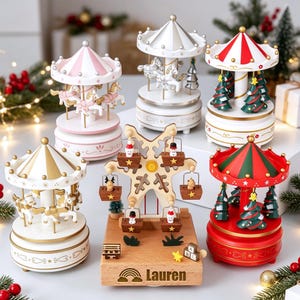 May include: A collection of five carousel music boxes and one wooden Ferris wheel music box. The carousels feature horses or Christmas trees under striped roofs. The wooden Ferris wheel has small hanging figures and the name Lauren engraved.