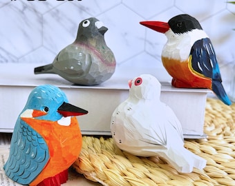 Puede incluir: Un conjunto de cuatro figuras de pájaros de madera talladas a mano. Los pájaros están pintados en varios colores, incluyendo azul, naranja, gris y blanco. El texto "4PCS Set" está en la parte superior. Ideal para la decoración del hogar.