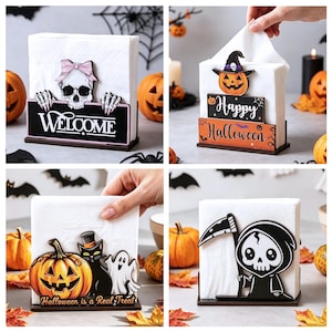 May include: A set of four wooden napkin holders featuring Halloween-themed designs including a skull with a pink bow, a pumpkin with a witch hat, a black cat with a pumpkin, and a grim reaper, all holding white paper napkins in upright slots.